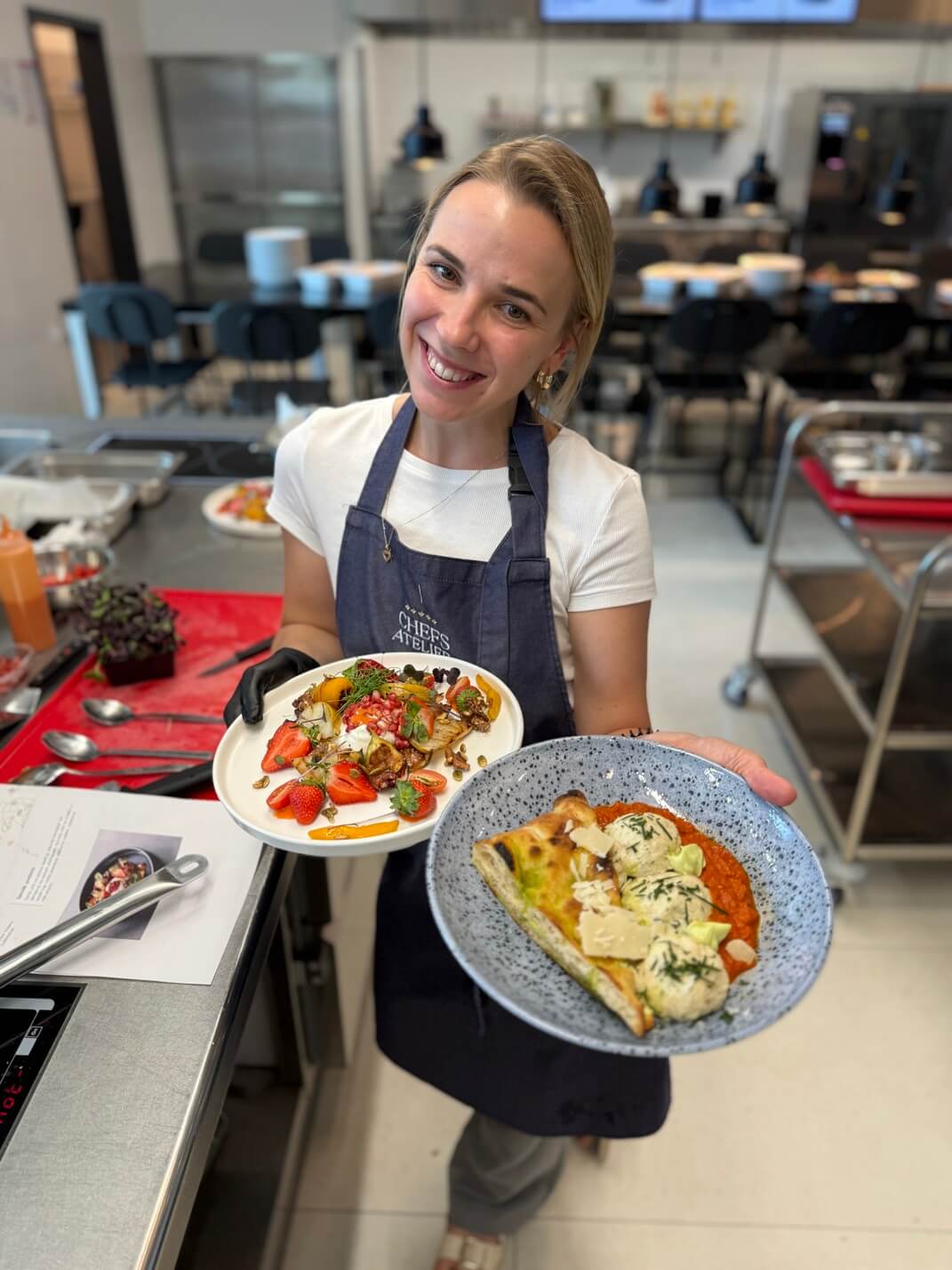 Izabela - Szef Kreacji Kulinarnych, trzymająca talerze z jedzeniem